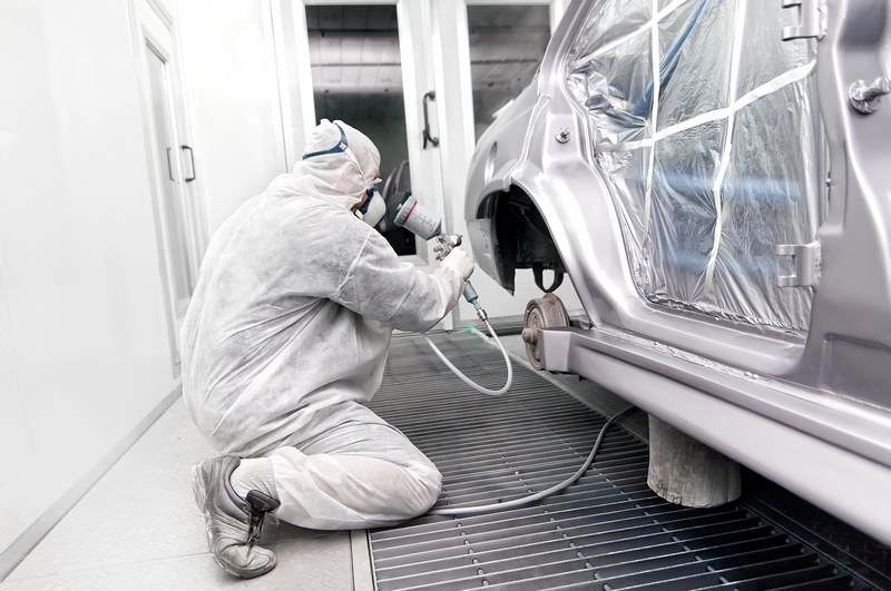 Worker,Painting,A,Grey,Car,In,A,Special,Garage,,Wearing